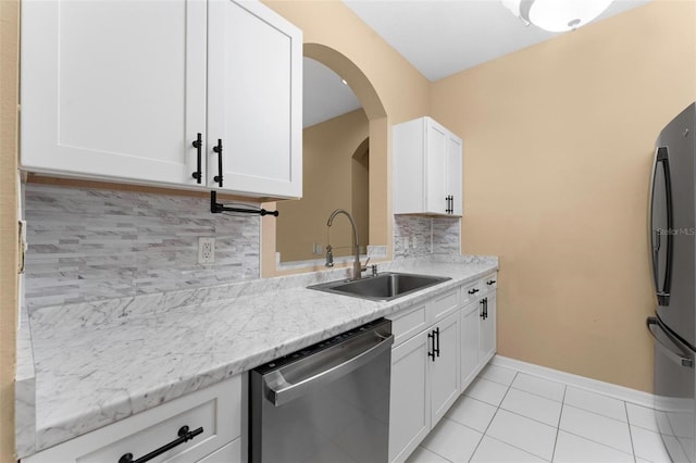 kitchen with white cabinets, backsplash, sink, and appliances with stainless steel finishes