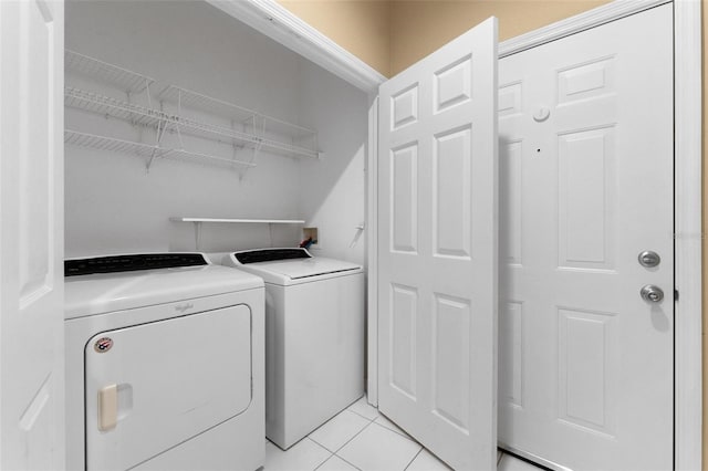 laundry area with light tile patterned flooring and washer and dryer