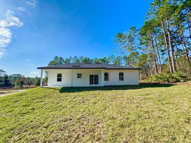 back of house featuring a lawn