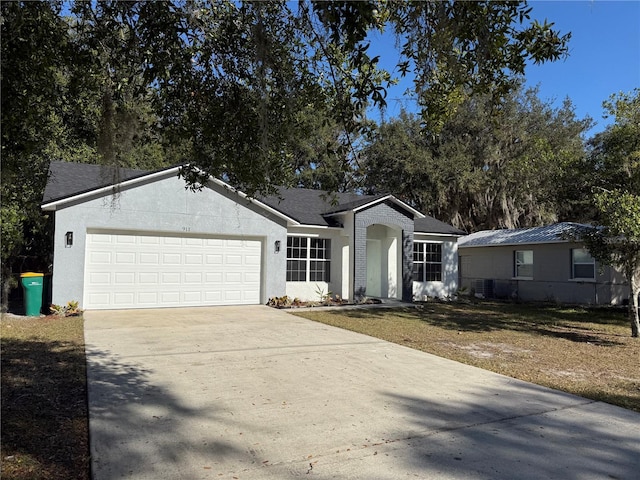 ranch-style home featuring a garage, concrete driveway, roof with shingles, and stucco siding