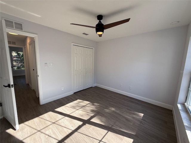 unfurnished bedroom with baseboards, visible vents, and dark wood finished floors