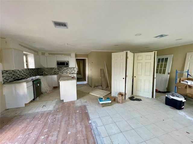 kitchen featuring decorative backsplash, white cabinetry, a center island, and dishwasher