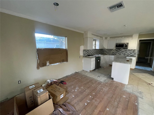 kitchen featuring decorative backsplash, white cabinetry, light stone countertops, and ornamental molding