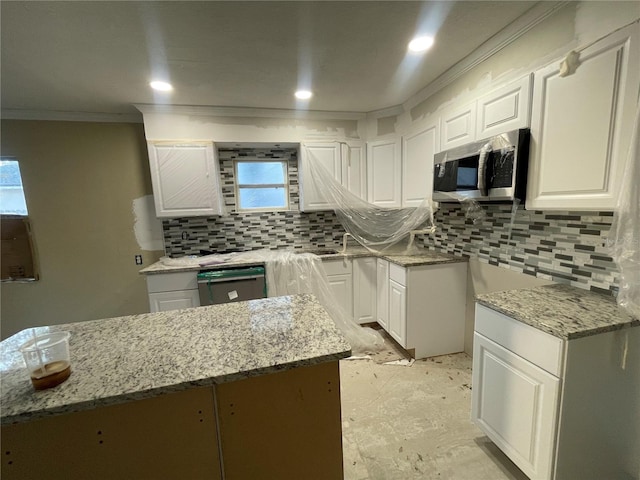 kitchen with dishwashing machine, white cabinets, and light stone countertops