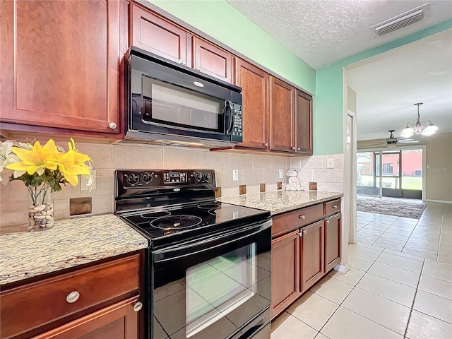 kitchen with black appliances, light stone countertops, light tile patterned floors, a textured ceiling, and a notable chandelier