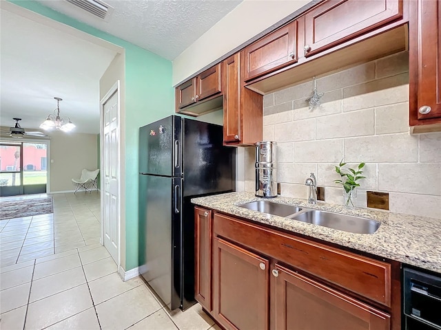 kitchen with ceiling fan with notable chandelier, black appliances, sink, light tile patterned floors, and decorative light fixtures