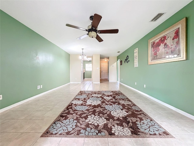 unfurnished room with light tile patterned flooring and ceiling fan with notable chandelier