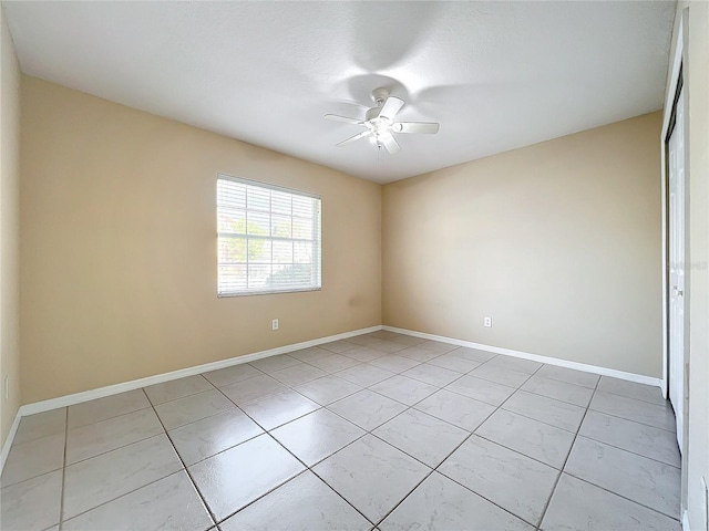 empty room featuring ceiling fan and light tile patterned flooring