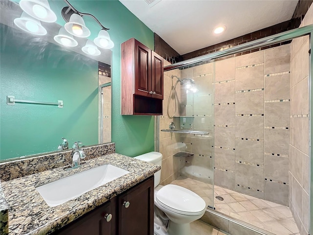 bathroom featuring vanity, toilet, and a shower with shower door