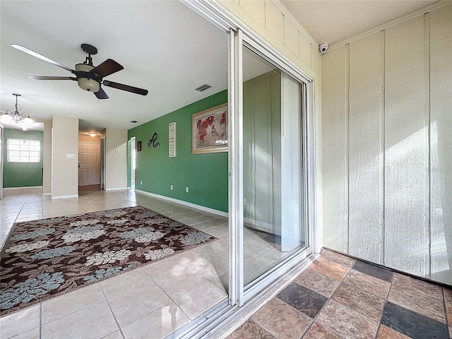 interior space with ceiling fan with notable chandelier