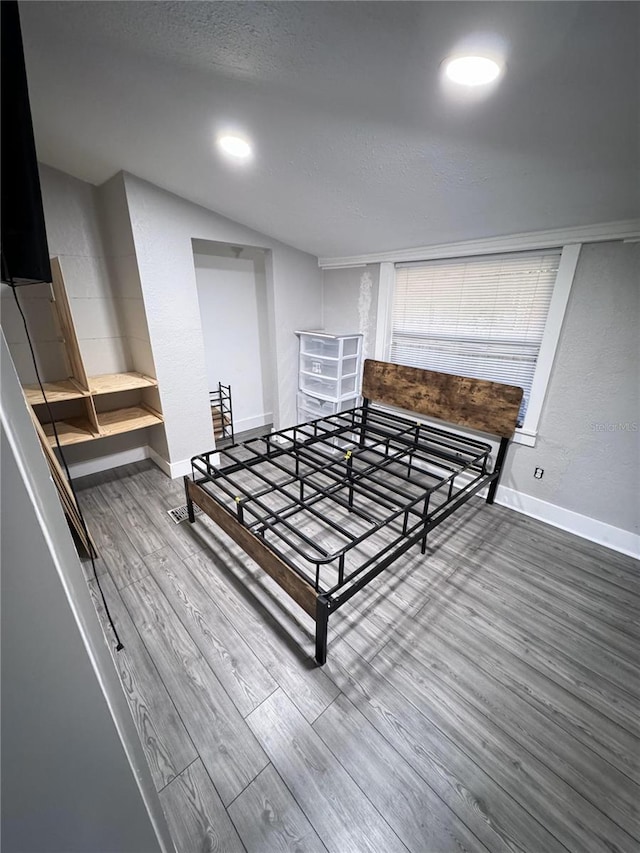 bedroom featuring wood-type flooring and vaulted ceiling