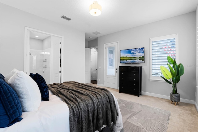 bedroom featuring light carpet, visible vents, ensuite bath, and baseboards