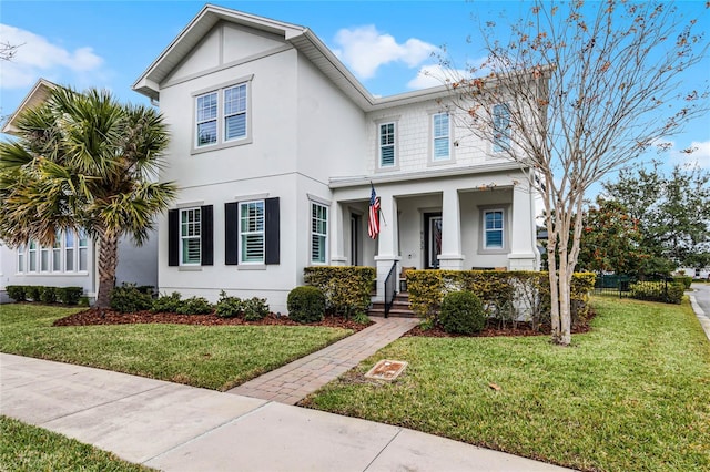 view of front of home featuring covered porch, stucco siding, and a front lawn