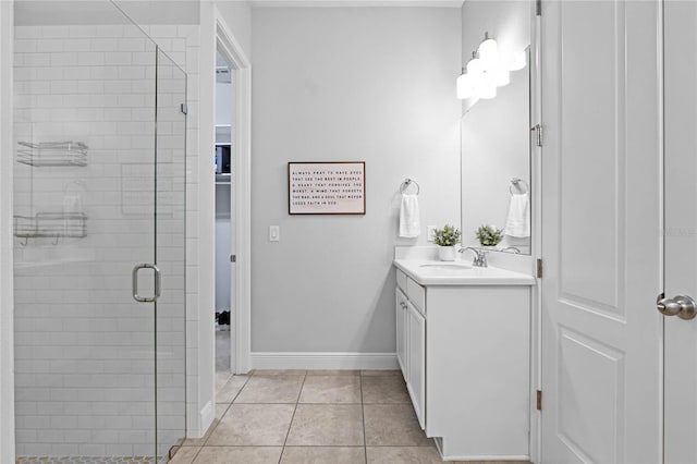 bathroom featuring tile patterned floors, baseboards, vanity, and a shower stall