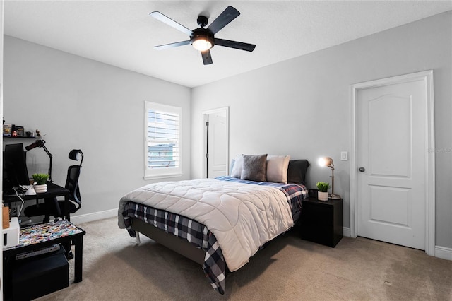 bedroom featuring light carpet, a ceiling fan, and baseboards