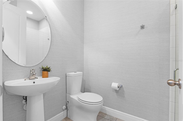 bathroom featuring tile patterned flooring, toilet, and baseboards