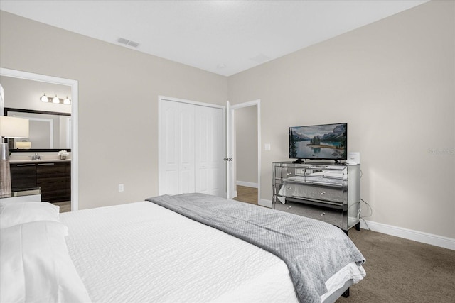 bedroom with carpet, ensuite bathroom, and a closet