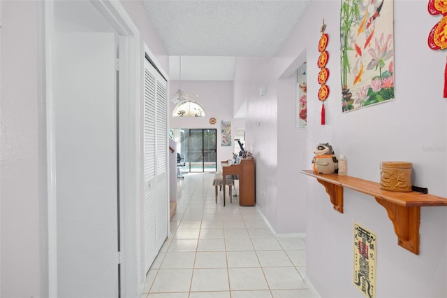 hall featuring light tile patterned floors and a textured ceiling