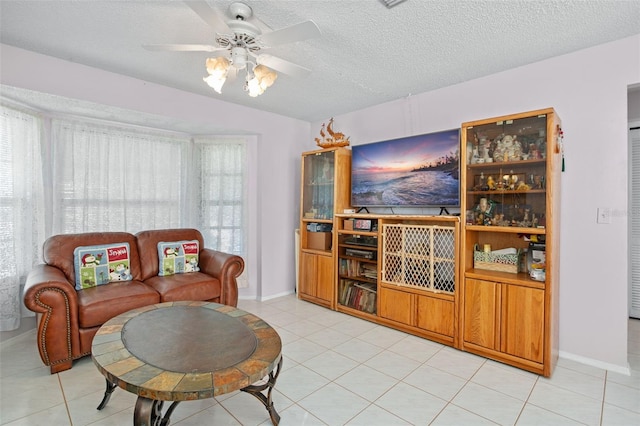 living room with light tile patterned floors, a textured ceiling, and ceiling fan