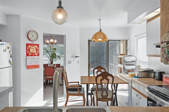 dining space featuring light tile patterned floors and a chandelier