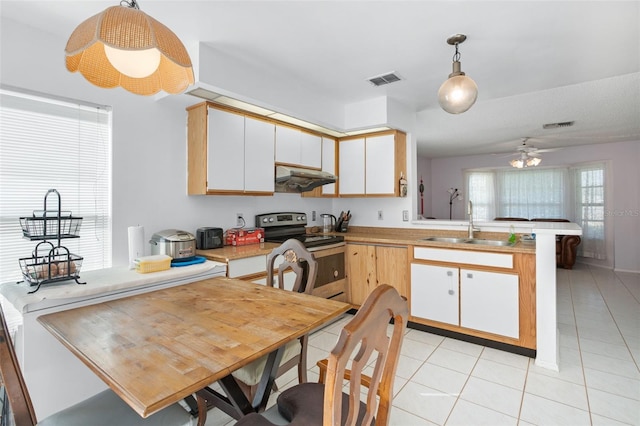 kitchen with kitchen peninsula, ceiling fan, sink, electric range, and hanging light fixtures