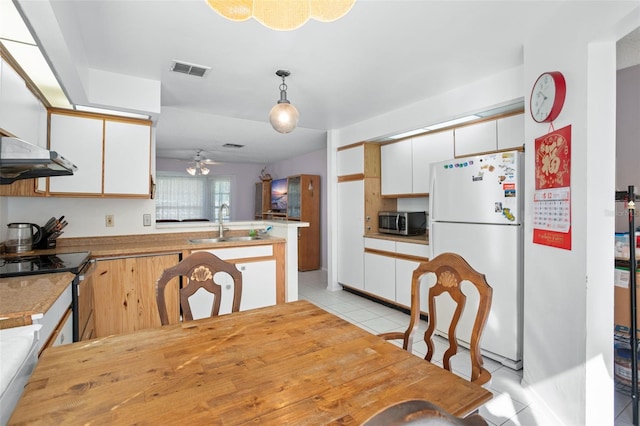 kitchen featuring kitchen peninsula, stainless steel appliances, sink, decorative light fixtures, and white cabinets