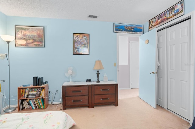 carpeted bedroom with a closet and a textured ceiling