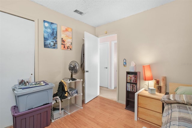 bedroom featuring light wood-type flooring and a textured ceiling