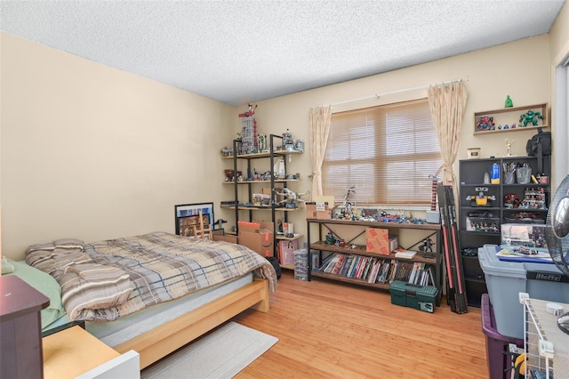 bedroom with hardwood / wood-style floors and a textured ceiling