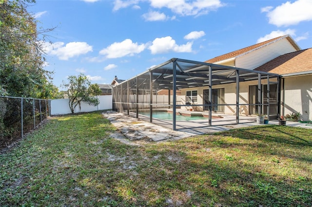 view of yard with a fenced in pool, glass enclosure, and a patio area