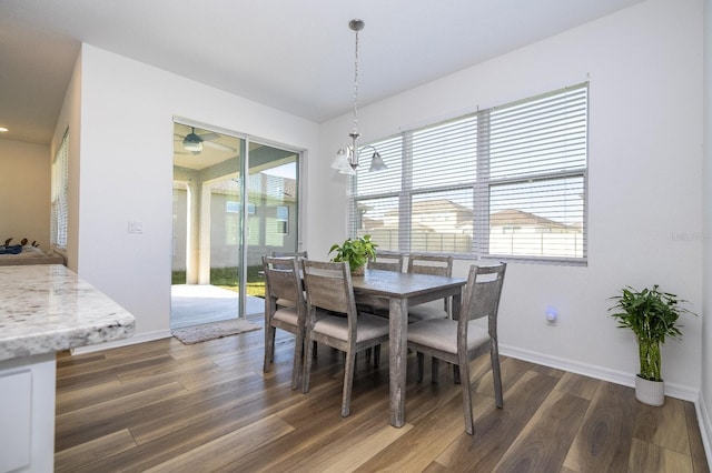 dining area with a healthy amount of sunlight, dark hardwood / wood-style floors, and a notable chandelier