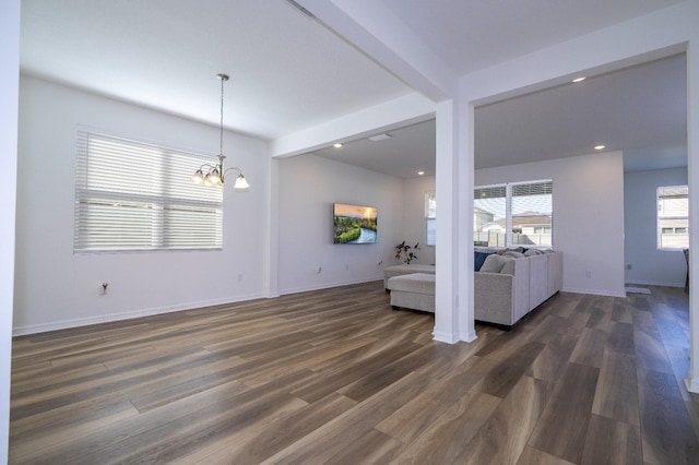 unfurnished living room with beamed ceiling, a chandelier, and dark hardwood / wood-style floors