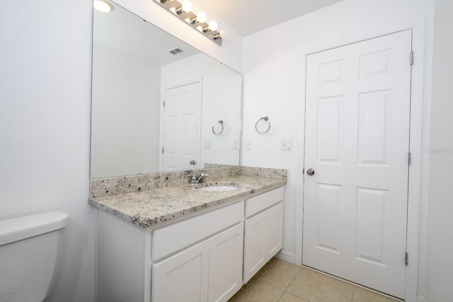 bathroom featuring tile patterned flooring, vanity, and toilet