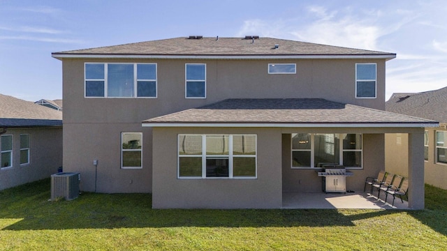 rear view of property with a yard, a patio, and central AC unit