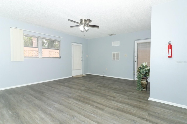 empty room with dark hardwood / wood-style floors, ceiling fan, and a textured ceiling