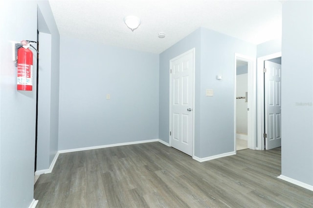 unfurnished room with a textured ceiling and light wood-type flooring