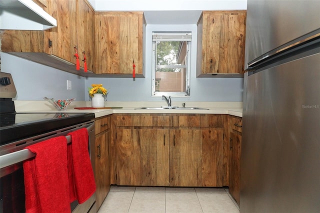 kitchen featuring light tile patterned floors, stainless steel appliances, and sink