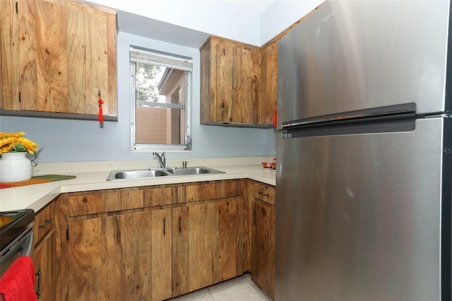 kitchen featuring light tile patterned flooring, stainless steel fridge, black range with electric cooktop, and sink