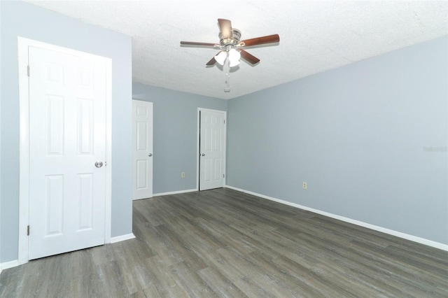 unfurnished bedroom with dark hardwood / wood-style flooring, a textured ceiling, and ceiling fan