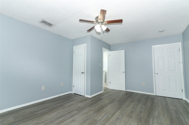 unfurnished bedroom with a textured ceiling, dark hardwood / wood-style flooring, and ceiling fan