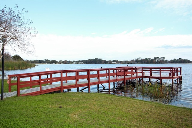 dock area with a lawn and a water view