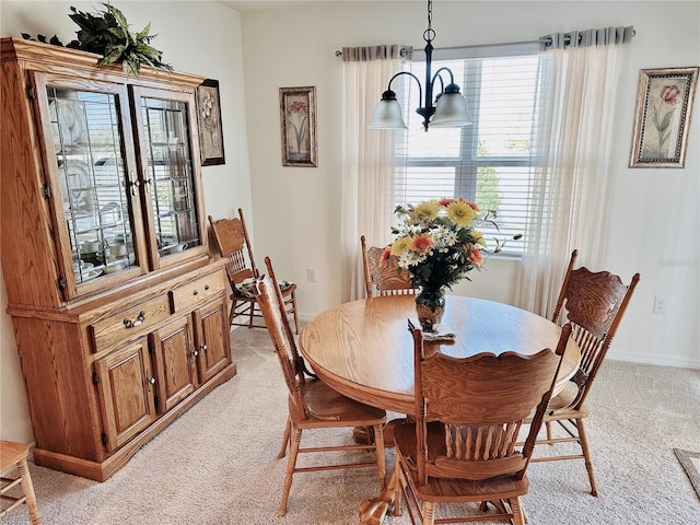 dining area with light colored carpet and a notable chandelier