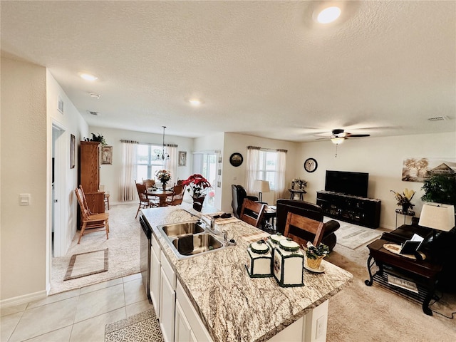 kitchen with white cabinetry, ceiling fan, a sink, dishwasher, and open floor plan