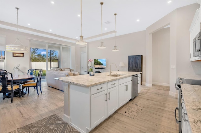 kitchen featuring white cabinetry, light stone counters, decorative light fixtures, and appliances with stainless steel finishes