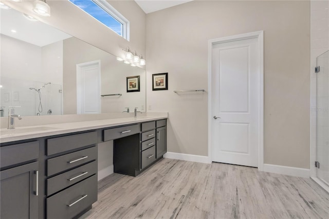 bathroom with hardwood / wood-style flooring, vanity, and walk in shower