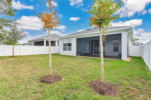 rear view of property featuring a sunroom and a yard