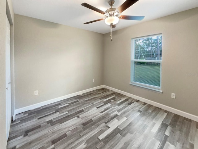 spare room featuring ceiling fan and dark wood-type flooring