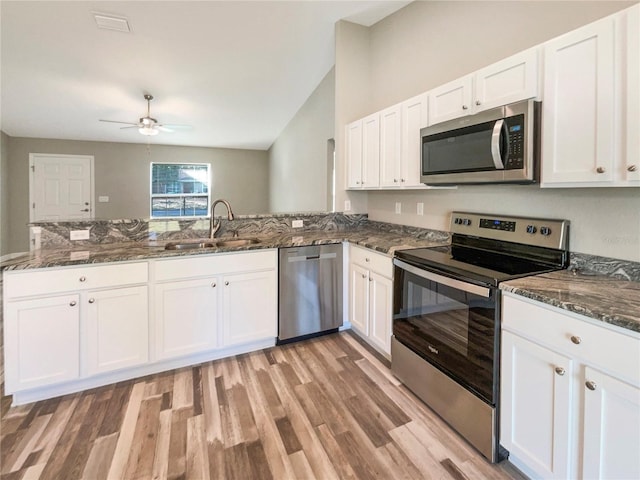 kitchen featuring appliances with stainless steel finishes, white cabinetry, and sink