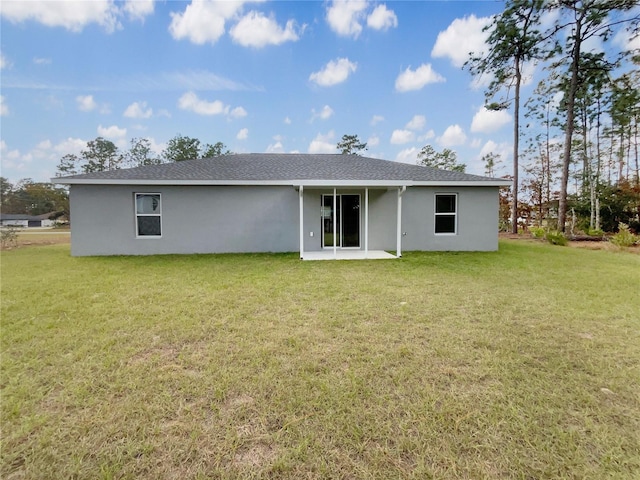 rear view of property featuring a lawn