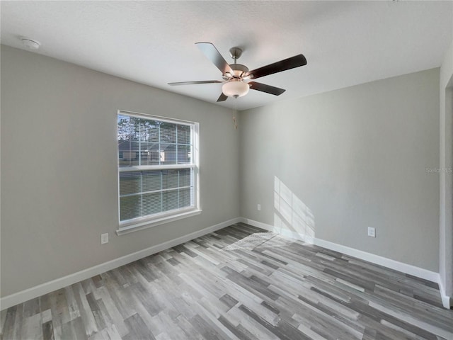 empty room with hardwood / wood-style flooring and ceiling fan